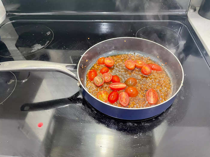 Add the halved cherry tomatoes to the skillet and cook for 1-2 minutes until they start to soften.