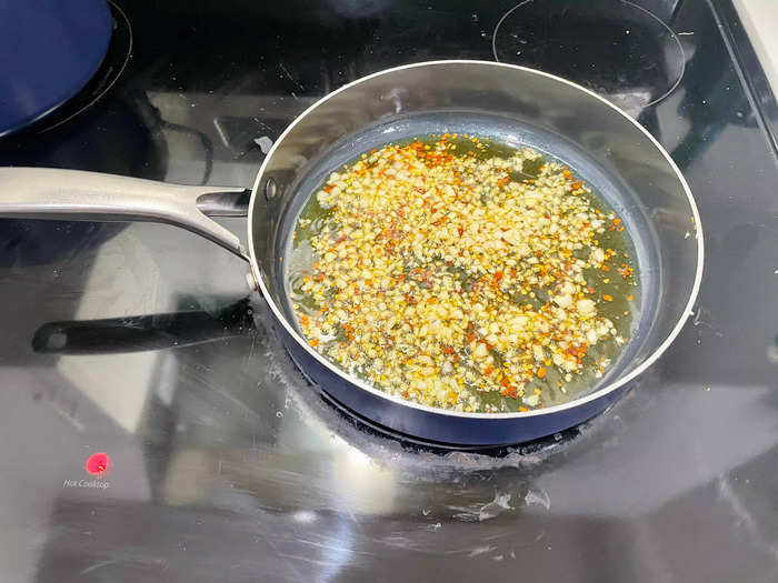 Then, in a large skillet, heat the olive oil over medium-high heat. Add the minced garlic and red pepper flakes (if using) and sauté for 1-2 minutes until fragrant.