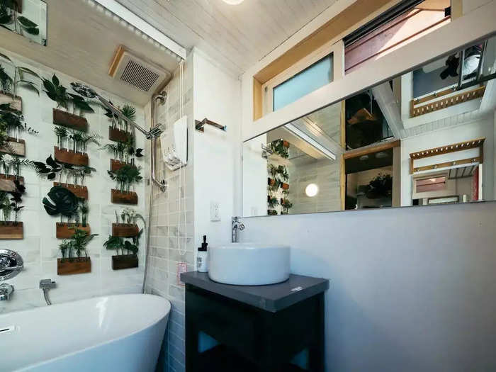 The bathroom has a large mirror in front of the sink as well as on the ceiling.