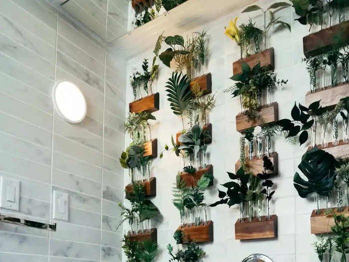 The bathroom features a wall next to the bathtub with more than 24 planters.