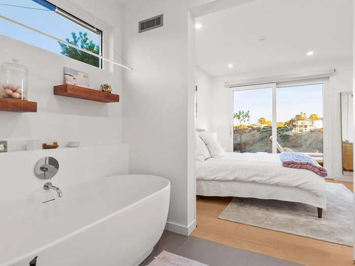 Off the primary bedroom is a bathroom with wood details and a standalone bathtub.