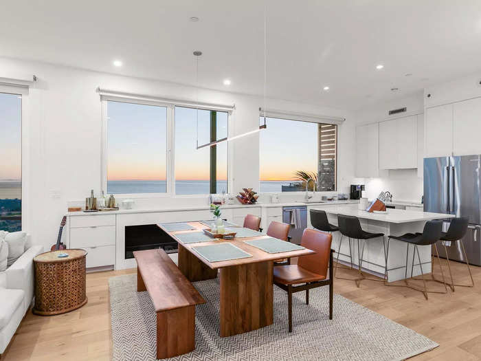 The dining room has an electric fireplace and a mix of chairs and bench seating.